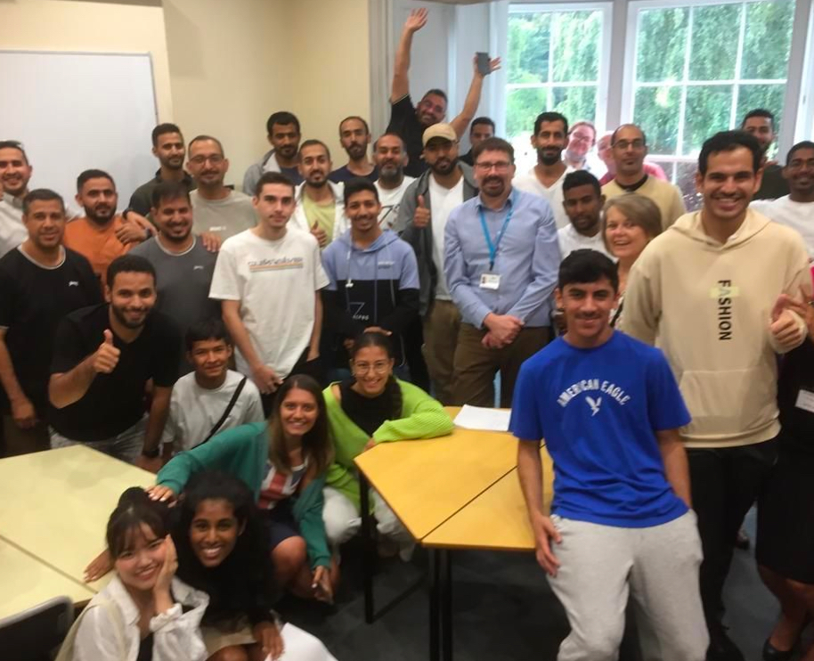 A group of people posting for a photo on a general english course in England.